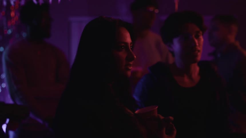 A woman is talking to another person in a night club