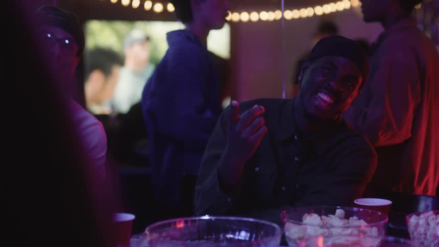 Friends sitting at a table at a party talking and laughing