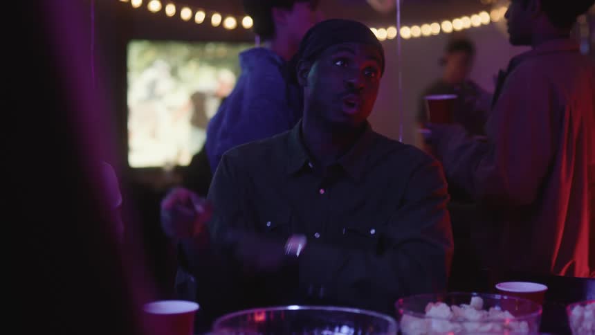 A black man speaks while sitting at a table