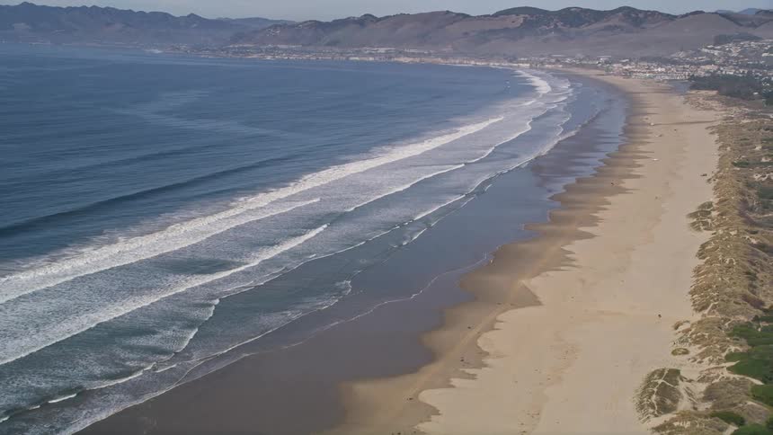 Aerial panorama of a residential neighborhood on the edge of a vast and extensive beach