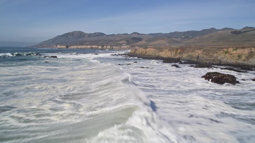 Aerial panorama of the sea with waves reaching the coast of a peninsula