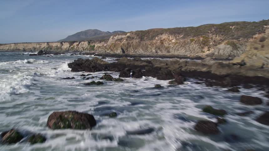 Footage of rugged coastline waves are crashing against the rocks