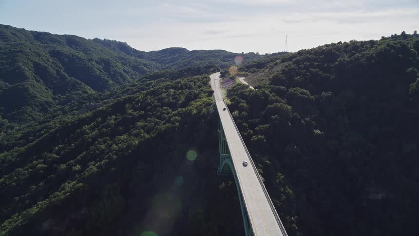 An aerial view of cars driving across a bridge