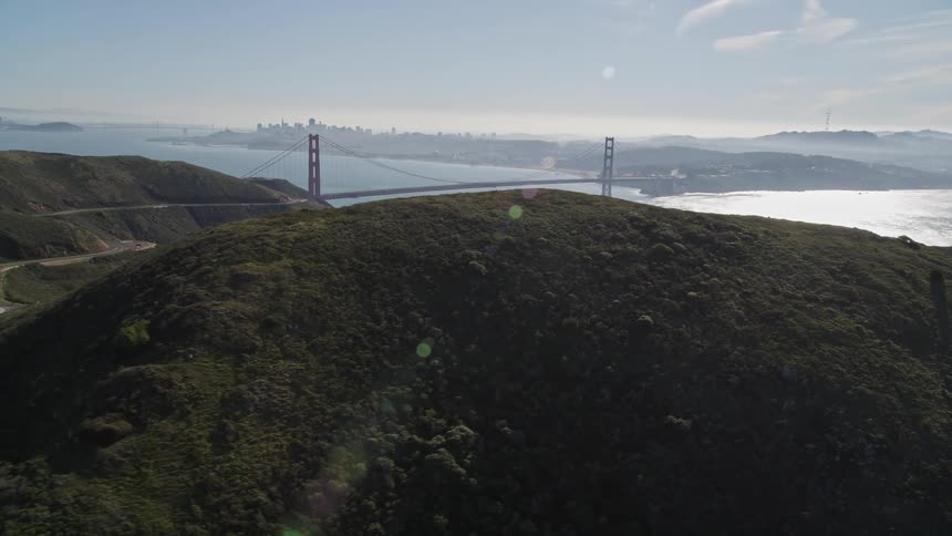 Aerial of the gold gate bridge in the distance behind the hillside