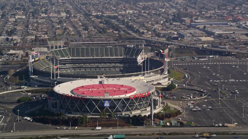 Two large stadiums next to a busy highway in a city