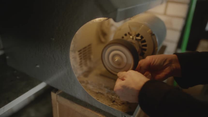 Female crafter shapes object on machine in a workshop