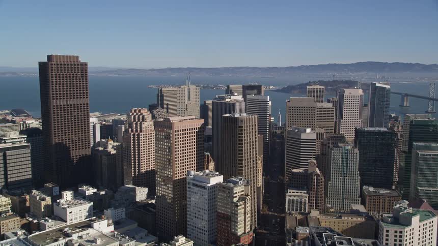 Aerial panorama of a metropolis with seaside skyscrapers and mountains on the horizon