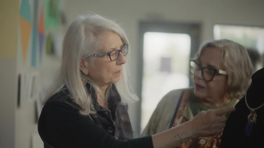 Two older women admiring a necklace in a jewelry store