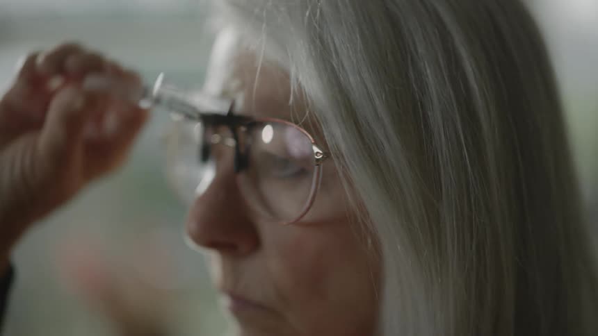 Close up of a woman wearing magnifying glasses
