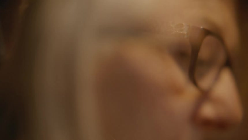 Side portrait of a woman with glasses concentrating
