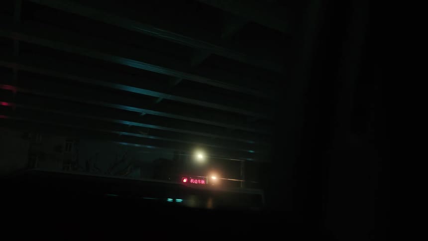 View from the window of a moving vehicle passing over an overpass through the city at night
