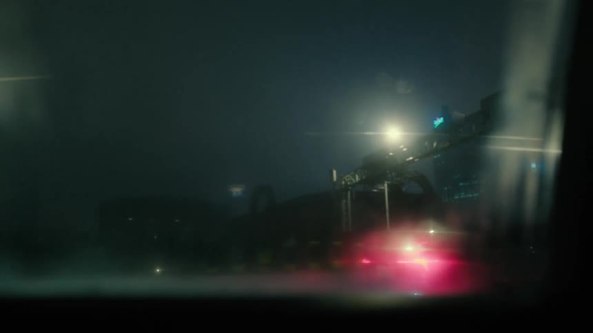 Vehicle drives along busy highway passing through city at night