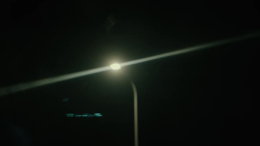 Passing street lights at night as seen from vehicle