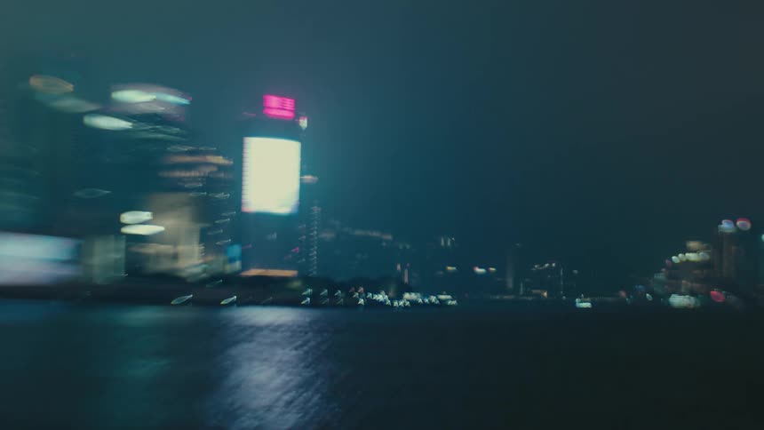Water reflects waterfront skyscrapers at night