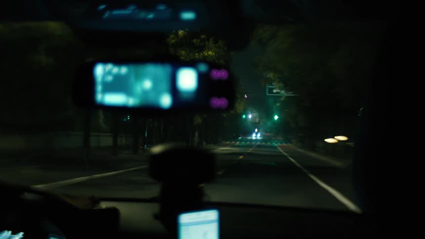 A car driving down a large avenue at night
