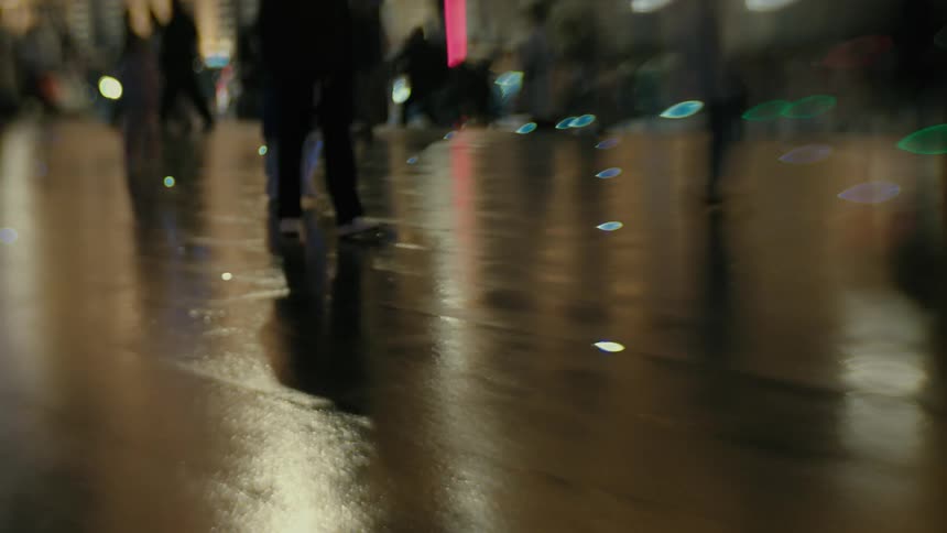 Pedestrians are walking on the wet sidewalk