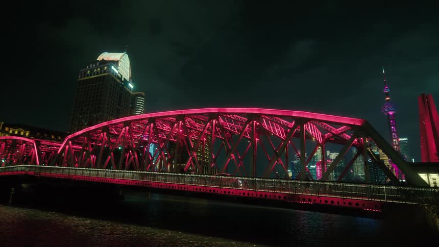 Cars drive on a bridge over a river in a city