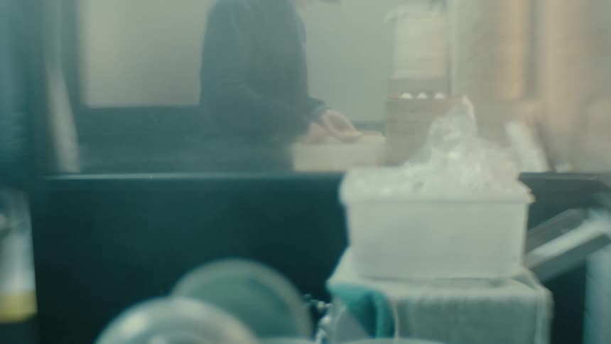 A person stands in a room moving something with their hands