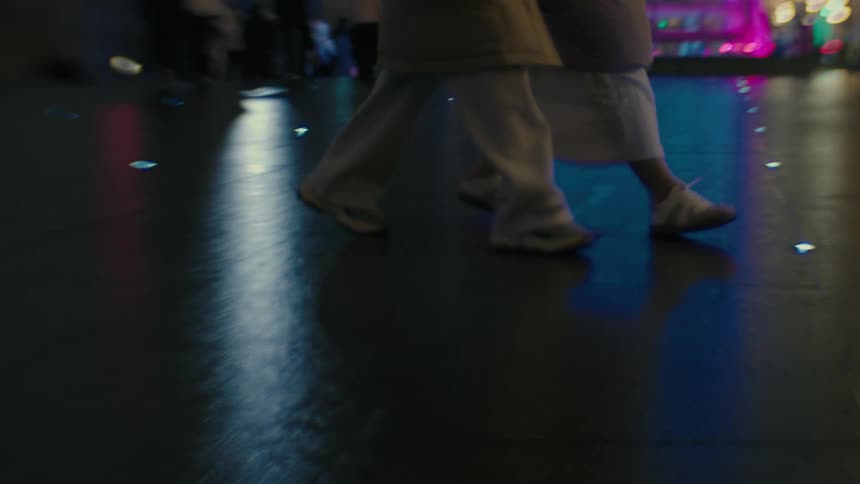 Street of a metropolis at night with people walking