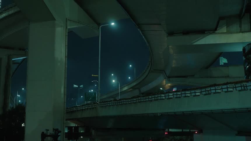 Overpass with vehicle traffic in a metropolis with skyscraper at night