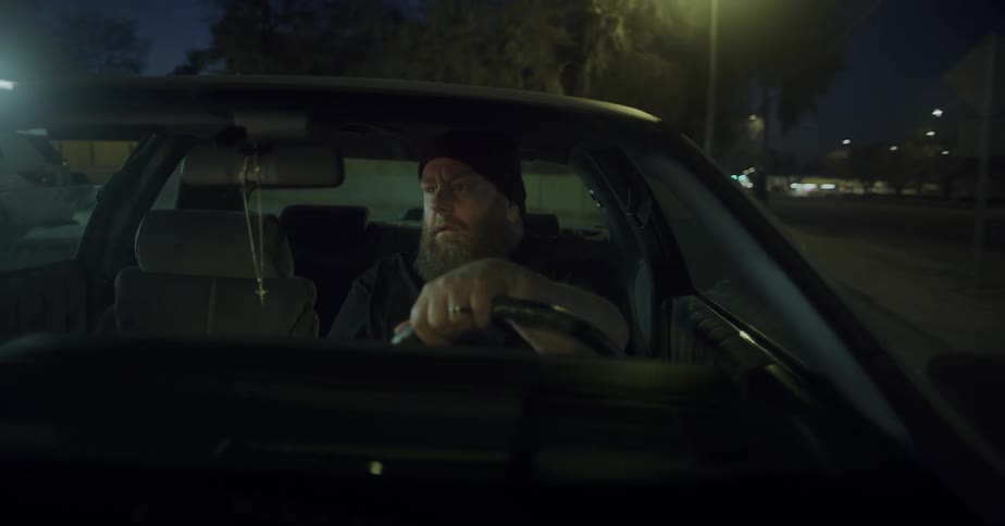 Man driving a vehicle through the streets of a city at night
