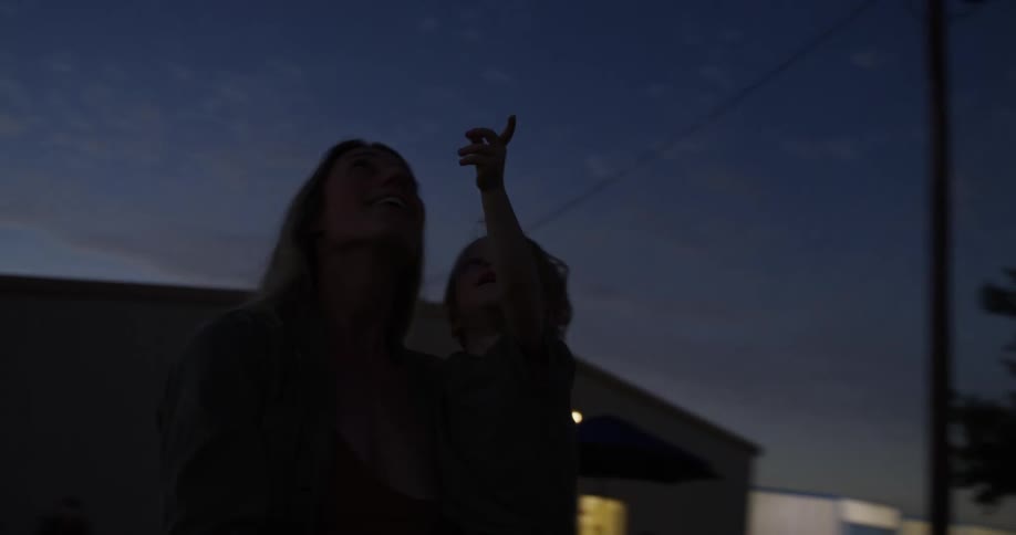 A mother and child points at a solar eclipse
