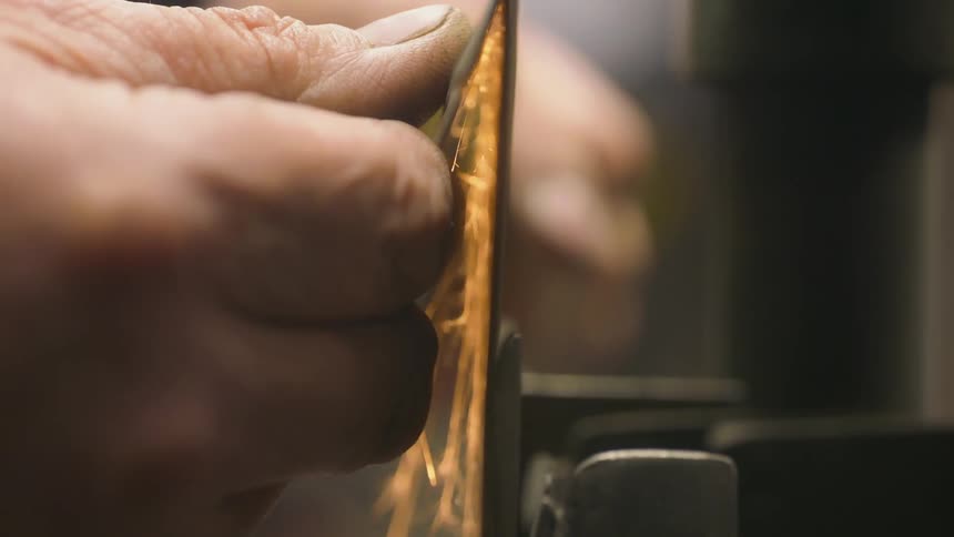 A worker polishes a piece of metal