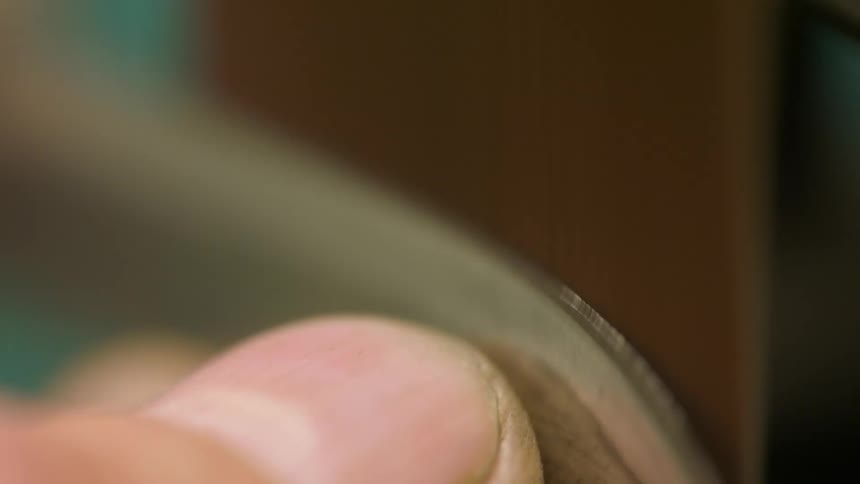 Extreme closeup of a persons finger shaping a blade