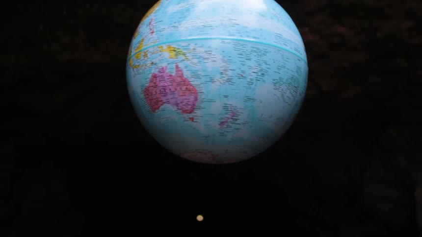 Earth globe orbiting in a cave in a natural environment