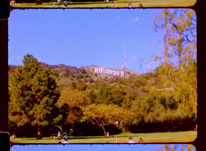 People relaxing at a park with the hollywood sign in distance