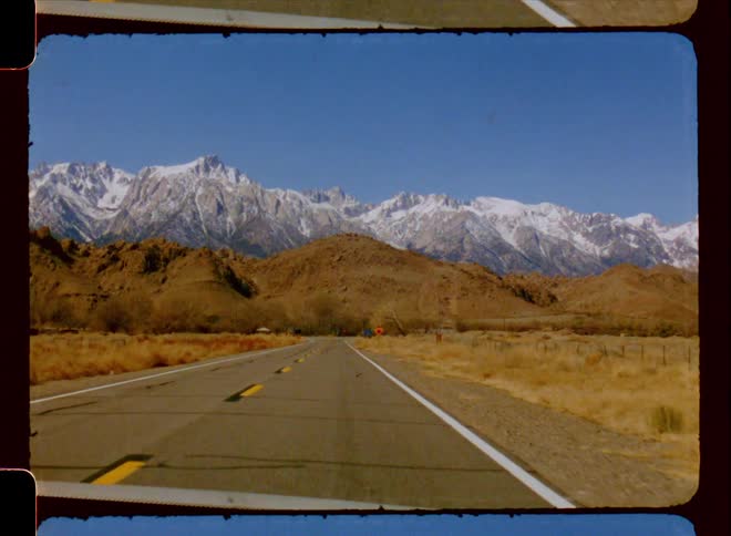 A road clip of grass land and mountain