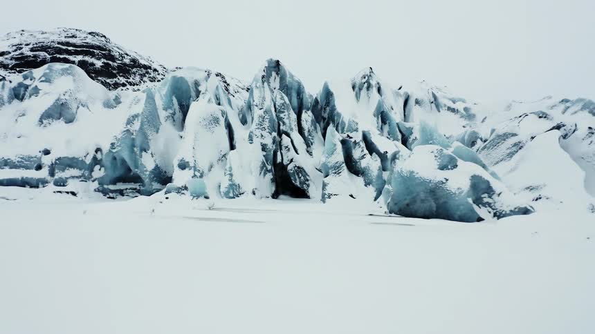 Panorama of sharp rocks and mountains on the horizon covered with snow on a cloudy day