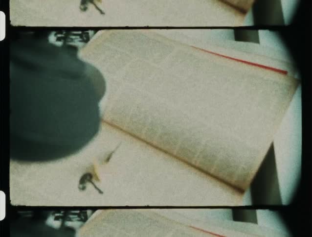 A person prepares a cup of tea over a book next to a live butterfly