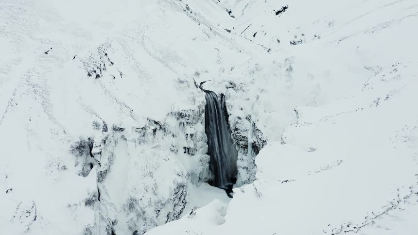 A waterfall runs into a mountain valley