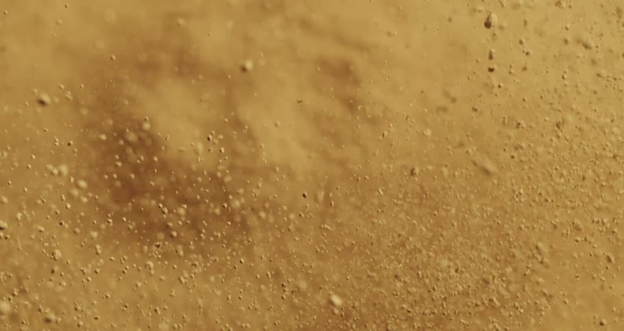Closeup on a soil with sand that explodes in slow motion