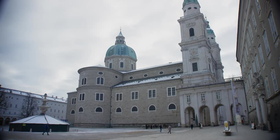 People move through plaza near Salzburg Cathedral in Salzburg, Austria