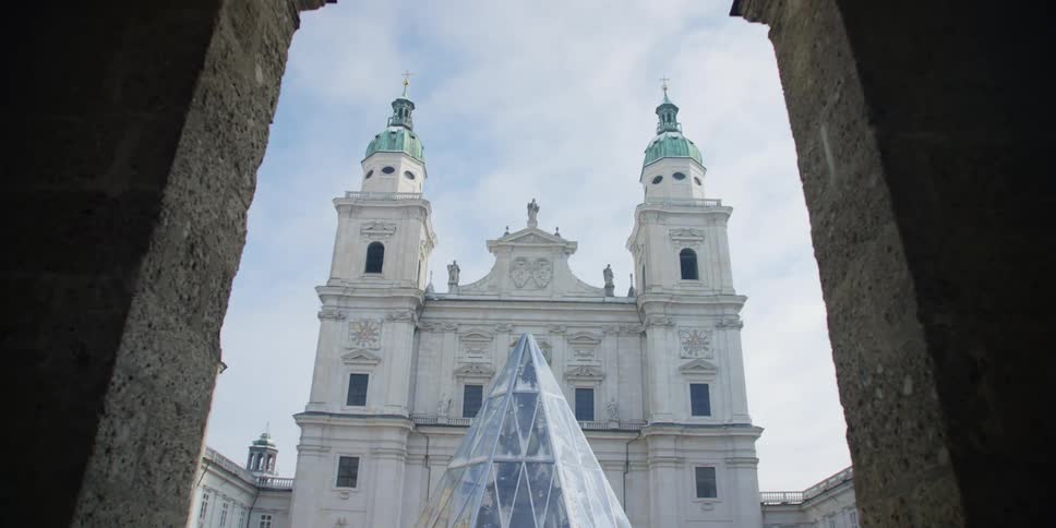 Walking through the archway leading up to the glass dome and front facade of Salzburg Cathedral, Austria