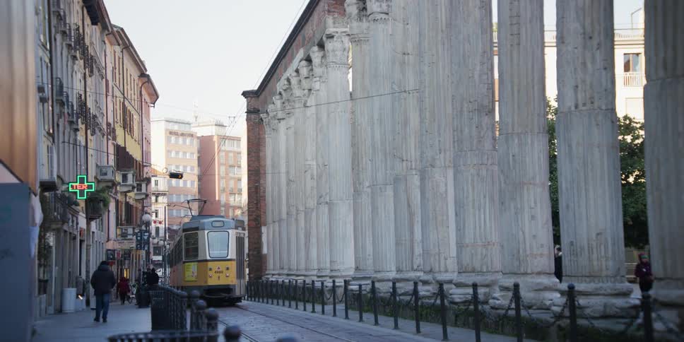 Public train passing past the Columns of San Lorenzo in Milan