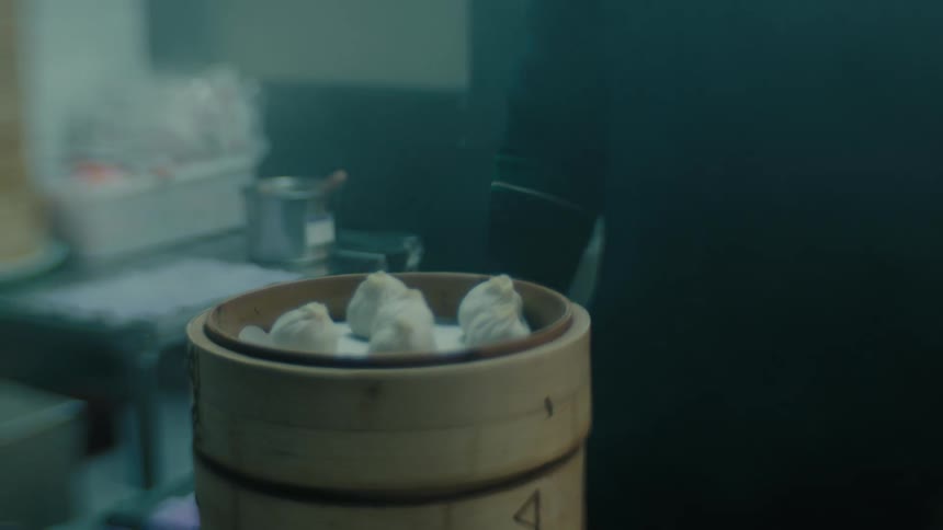 Oriental dumplings being steamed in a wooden bowl