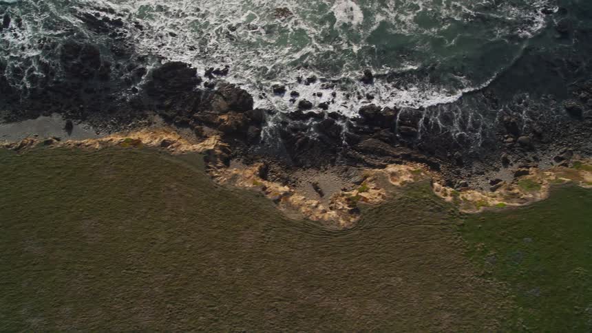 A lone house sits on the edge of a rocky beach