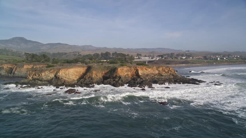 Ocean waves hitting a small peninsula