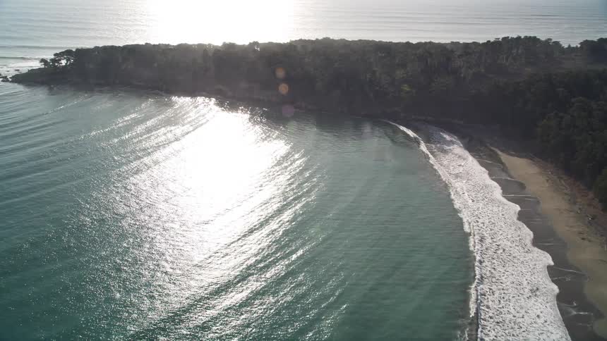 Waves move ashore in a bay by buildings