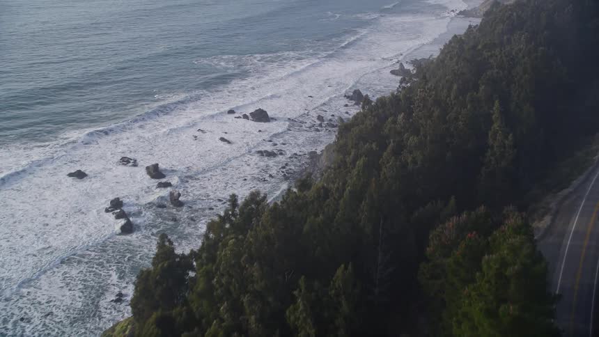Aerial panorama of a paved road on a mountain by the sea