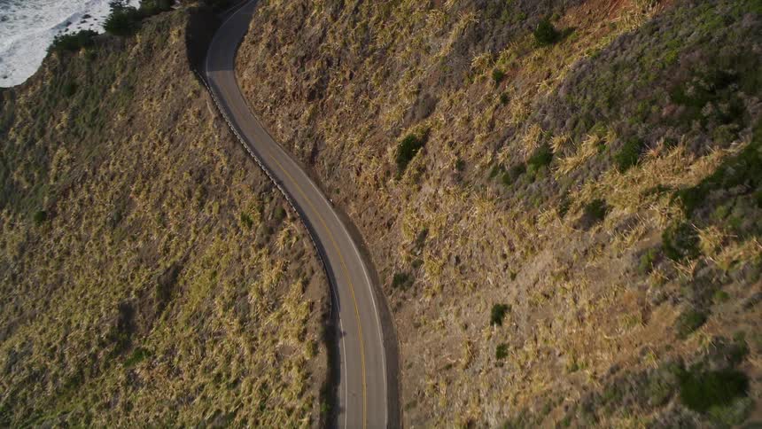 A road runs along the shore and mountain