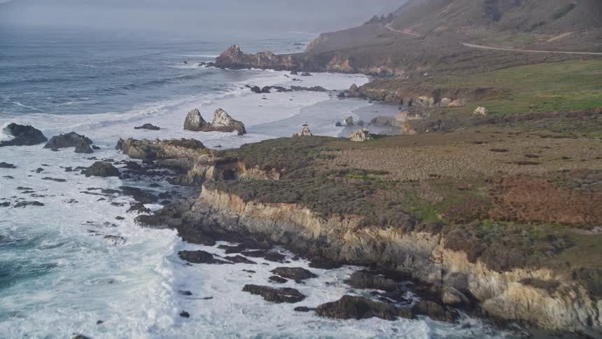 Aerial scene of an extensive sea reaching the rocky coast during the day
