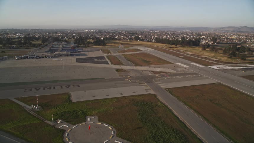 Aerial panorama of an airstrip in an urban city with mountains on the horizon