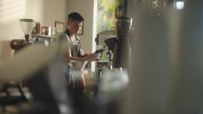 Man preparing a coffee in a machine in a cafe