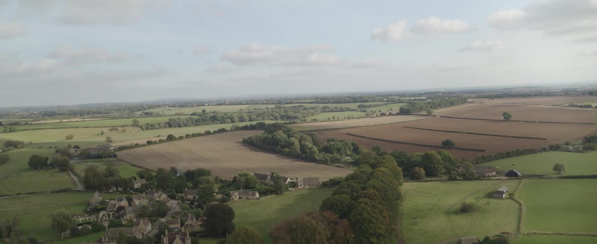Crop fields surround rural town and nearby farms on a cloudy day