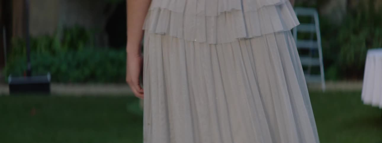 Closeup of a womans waist walking outdoors wearing a long dress