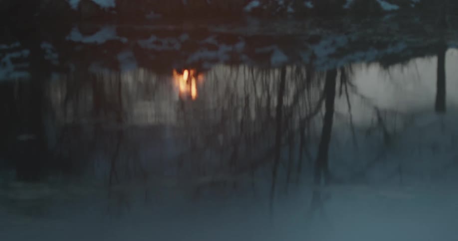 A fire burns on a river bank
